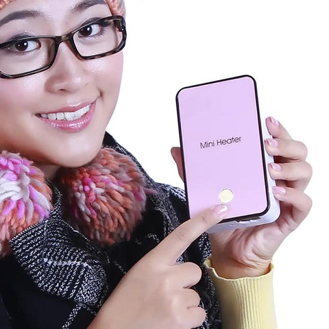 Person holding a pink Mini Portable Room Heater For Desk And Office, Energy Saving Quiet Electric Fan Heater, showcasing compact design.