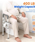 Man sitting on Raised Toilet Seat With Handles For Seniors Cozy Padded Elevation Riser Comfortable 350 Pound Capacity Adjustable Handicap Toilet Riser Gray FSA Eligible Now in bathroom, showcasing weight capacity and safety features.