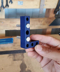Heavy Duty Woodworking Square And Center Finder With An 11 32 Marking Hole, blue metal L-shaped tool being held.