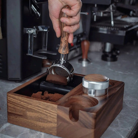 Hand using portafilter with wood handle on Straight Up Heavy Duty Wooden Espresso Knock Box Tamping Station.