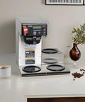 Front view of Dual Voltage Commercial 12 Cup Coffee Maker With Back To Back Brews Three Warmers Large 200 Oz Tank Programmable Brew Level And Temperature Cold Brew Lockout Grey Finish Built For Busy Cafes And Offices