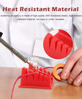 Close-up of Magnetic Helping Hands Soldering Station with five slot wire holder and soldering iron in use, demonstrating heat resistance.