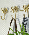 Kickass Heavy Duty Wall Mounted Coat Hook Bulletproof Metal Clothes Hanger with decorative bows holding accessories.