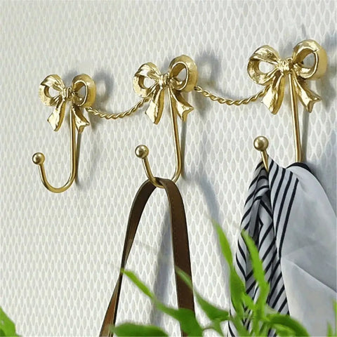 Kickass Heavy Duty Wall Mounted Coat Hook Bulletproof Metal Clothes Hanger with decorative bows holding accessories.