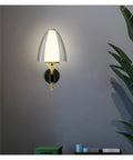 Straight Up Modern Led Wall Sconce With Soft Glowing Acrylic Shade lights up a wall near a plant, stylish and functional.