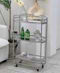 Slick Rolling Kitchen Island Trolley With Ample Storage Shelves And Quiet Locking Wheels For Mobile Coffee Bar Station or Heavy Duty Stainless Steel Tool Caddy Rig with three shelves and green bottles.