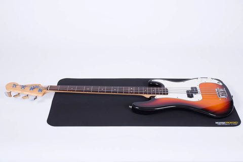 Guitar on a large 36x17 inch work mat for string changes and setup, anti slip TPE material safe on finishes, instrument maintenance.
