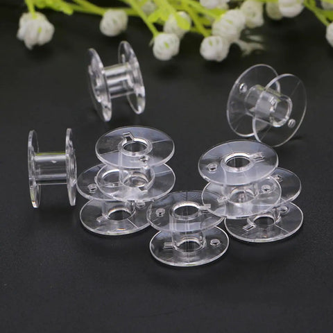 15 Piece Sewing Machine Tool Kit With Bobbins, Screwdrivers, Seam Ripper, Threading Tool And Brush For Home Use And Beginners Easy DIY Sewing Supplies For Quick Repairs And Small Projects. clear plastic sewing machine bobbins on black background