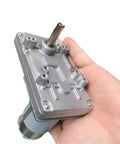Badass 555 Size Dc Motor Paired With A Precision Steel Worm Gear Reducer 12 Volt And 24 Volt Drive Units held in hand.