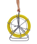 Four Twenty Five Foot Fiberglass Fish Tape With Sturdy Guide Spool For Smooth Wire Routing Through Tight Conduit Built For Electricians And Utility Crews Knocking Out Tough Telecom Jobs Without A Scratch Or Snag, yellow fiberglass fish tape on metal spool.