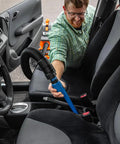 Man using 15 Inch Click Connect Needle Nose Crevice Tool for Shop Vac Vacuum Cleaner on car seats, showing narrow tip in action.