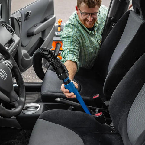 Man using 15 Inch Click Connect Needle Nose Crevice Tool for Shop Vac Vacuum Cleaner on car seats, showing narrow tip in action.