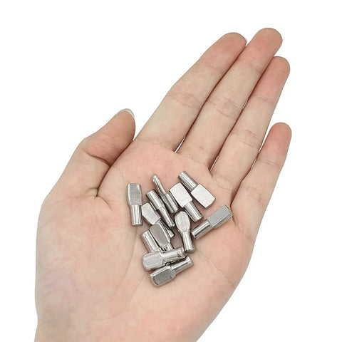 Person holding 100 Pack Nickel Plated Shelf Pins, 5mm Spoon Shape Shelf Support Pegs for Bookshelves