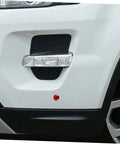 Zoomed view of car bumper showing stainless steel quick release latch system for engine bay access with red accent
