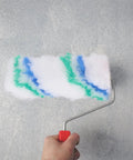 Close-up of a hand holding a paint roller with Twenty Four Piece Polyester Paint Roller Covers Yield A Dang Smooth Wall Finish With No Sweat Cleanup And Heavy Duty Build Perfect For Quick Home Reno Jobs That Call For A Knockout Factory Fresh Coat.