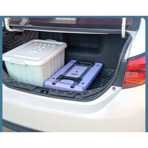 Heavy Duty Folding Trolley Cart With Slick Nylon Rollers And Sturdy Aluminum Frame in car trunk beside storage bin.