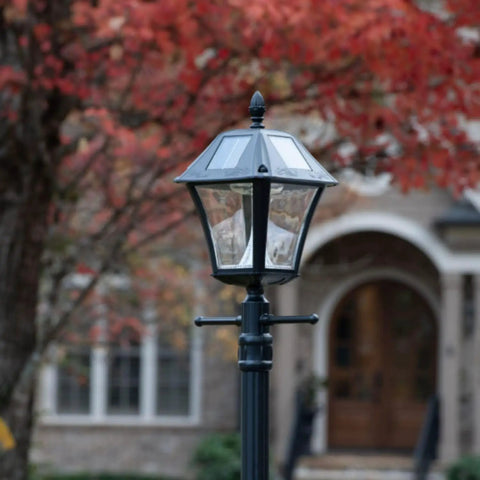 Baytown II Outdoor Solar Lamp Post with EZ Anchor Kit, Black Finish in autumn garden, showing dusk to dawn operation.