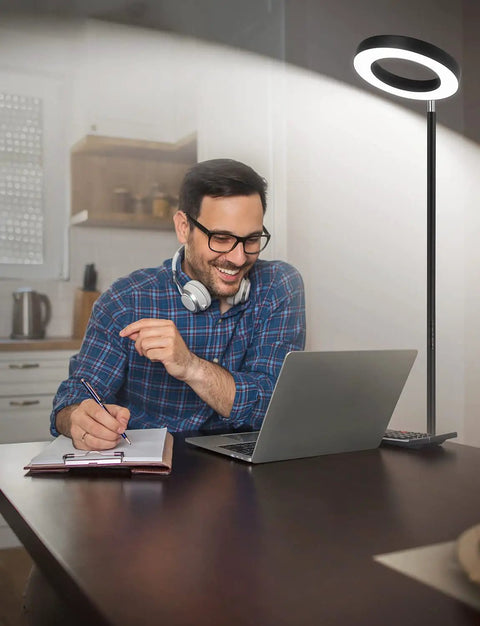 Man using laptop with Smart RGBW Floor Lamp With Double Side Lighting 2400 Lumen Dimmable LED Standing Lamp illuminating desk.