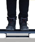 Bottom view of person standing on 22 X 12.5 Inch Aluminum Guitar Pedal Board With Power Supply Tray Carry Bag And Mounting Tapes Included Black Portable Lightweight For Gigging Musicians showcasing its strength and stability.
