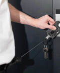 Person using Heavy Duty Retractable Badge Holder With Carabiner Clip And Keychain Reel 31.5 Inch Extendable ID Card Holder For Work Beefy Black Tactical Accessory For Easy ID Access And Key Chain in action