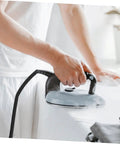 Person using electric iron connected with High Temperature Steam Iron Replacement Hose With Easy Install No Fuss Lightweight Flexible Tube