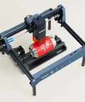 Front-left view of WAINLUX 4-pc laser engraver raiser kit on a blue frame with rails; red can on roller bed.