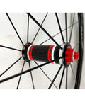 Close-up of 700C road bike wheelset with carbon fiber hub and 40mm matte aluminum rim quick release CV brake compatible stainless steel spokes