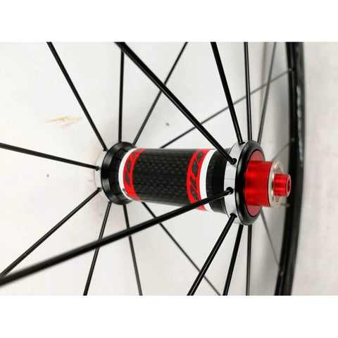Close-up of 700C road bike wheelset with carbon fiber hub and 40mm matte aluminum rim quick release CV brake compatible stainless steel spokes