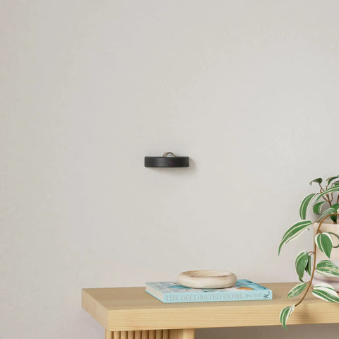 Wireless LED Spotlight Battery Powered Picture Light With Remote For Wall Art Display on a minimalist wall above a table.