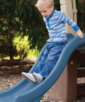 Child sliding down Tot Friendly Outdoor Kids Playset With Two Tier Swing Set, Slide, Climber, Crawl Space And Playhouse.