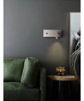 Slick LED Wall Sconces Infinite Dimming Switch Metallic Nickel Aluminum Build Zero Flick Eye Care mounted above a green couch.