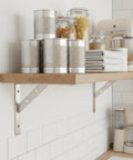 Stainless Steel Triangular Wall Shelf Bracket For Standard Wood Planks with kitchen items, silver finish, side view.