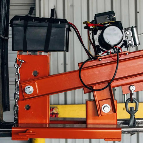 Heavy Duty Fork Mounted Jib Crane With Electric Winch features a battery and wiring on the telescopic boom, designed for warehouse use.