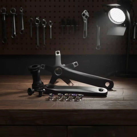 Lightweight 44T Hollow Aluminum Crankset With 152mm Arm And Bottom Bracket For Road Bikes Upgrade Anodized Finish Delivers Stiff Power Transfer And Smooth Pedal Response For Cyclists, black crank arms and bottom bracket laid out on a workbench