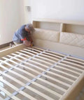 Man installing Heavy Duty Bed Rail Hooks And Universal Frame Connector Plates For Wooden Beds in a bed frame.