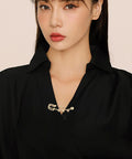Premium 20 Pack Of Versatile Loop Safety Pin Brooches To Clasp Sweaters Scarves And Denim Belts While Adding Instant Chic Vibes To Everyday Streetwear And Casual Fits, modeled on a black shirt.