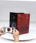 Sparkling 360 Rotating Turntable Display Stand For Jewelry Watches And Digital Products Mirror Base Electric Spin Platform showcasing a wooden speaker.