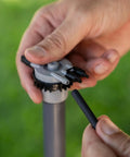Hands connecting tube to Six Port Drip Irrigation Manifold With Unregulated Free Flow For Easy Backyard Watering Connects Six Tubes