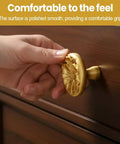 Hand holding Two Pack Zinc Alloy Cabinet Knobs With Floral 3D Design For Dressers Wardrobes And Cupboards on wooden drawer