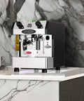 Slick One Group Automatic Espresso Maker In Shiny Copper Electronically Controlled Brewing with sleek chrome finish on marble counter.