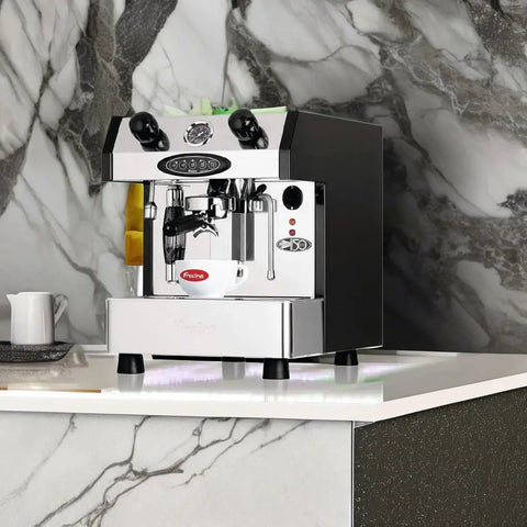 Slick One Group Automatic Espresso Maker In Shiny Copper Electronically Controlled Brewing with sleek chrome finish on marble counter.