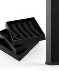 Stacked black 3x3 Square Rubber Furniture Wheel Cups with Anti Slip Grip next to a furniture leg, set of 4 for floor protection.