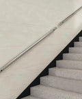 Heavy Duty Stainless Steel Handrail For Stairs And Decks Round Pipe Railing System Wall Mounted Indoor Outdoor 16 Foot Length mounted on white wall beside stairs.