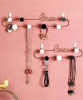 Hella Sturdy Decorative Wall Hooks Heavy Duty Metal Row Mounts For Hanging Coats Hats Keys Bags Rustic Iron Art Home Organizer on a pink wall.
