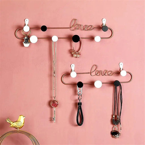 Hella Sturdy Decorative Wall Hooks Heavy Duty Metal Row Mounts For Hanging Coats Hats Keys Bags Rustic Iron Art Home Organizer on a pink wall.