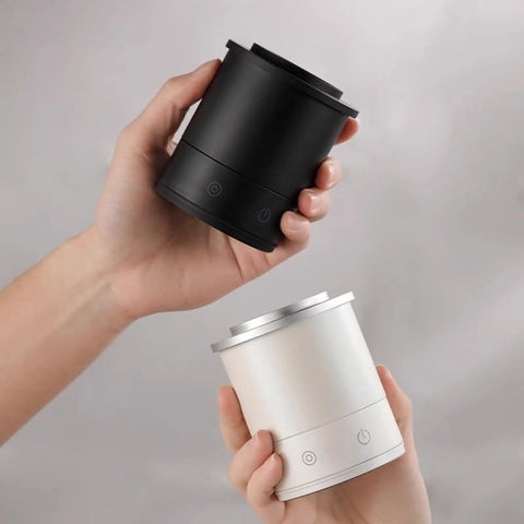 Two hands holding a black and a white Total Game Changer Aluminum Coffee Dosing Cup And Espresso Digital Scale Combo.