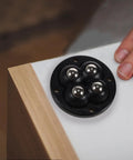Swivel Caster Wheels 360 Degree Rotation Self Adhesive 12pcs Mini, black circular base with stainless steel balls near wooden edge.