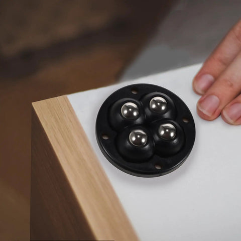 Swivel Caster Wheels 360 Degree Rotation Self Adhesive 12pcs Mini, black circular base with stainless steel balls near wooden edge.