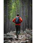 Hiker on rocky trail wearing PhotoSport 24L AW III Hiking Camera Backpack With Side Access And Removable Insert For Mirrorless Gear