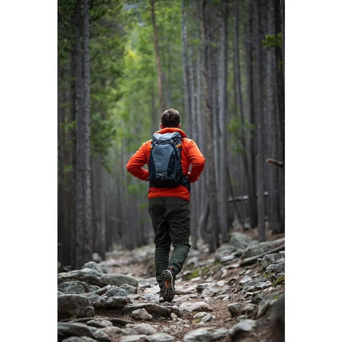 Hiker wearing 24L Hiking Camera Backpack With Side Access, Removable Camera Insert, and Accessory Strap System on forest trail